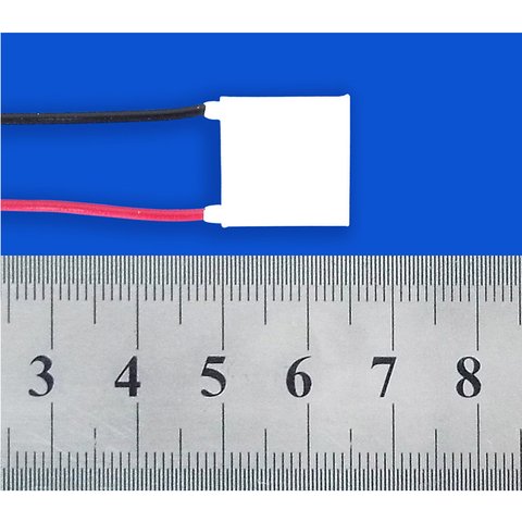 Analog Technologies TEC module (Peltier thermoelectric cooler) with lead wires, shown next to a ruler for scale
